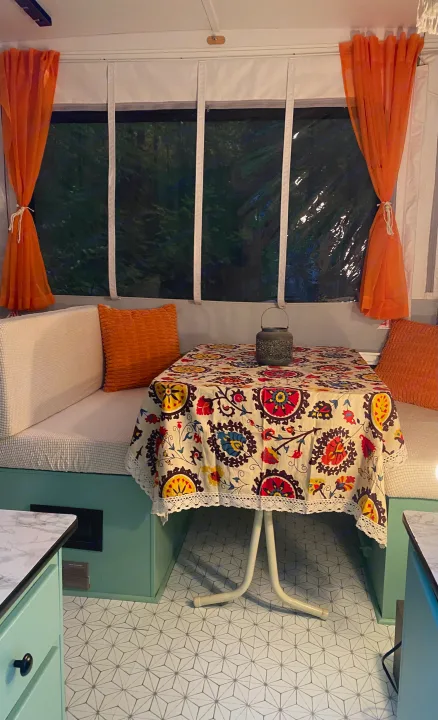 Cozy rv rental interior: bright dining area with patterned tablecloth, bench seating, & modern mint green accents. Perfect camper space.. Viking Recreational Vehicles, INC. Model 548 2000