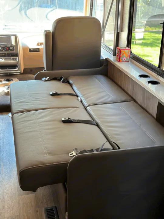 Spacious grey dinette seating with seatbelts and cupholders inside this RV rental, ready for your road trip.. Winnebago Sunstar 2021