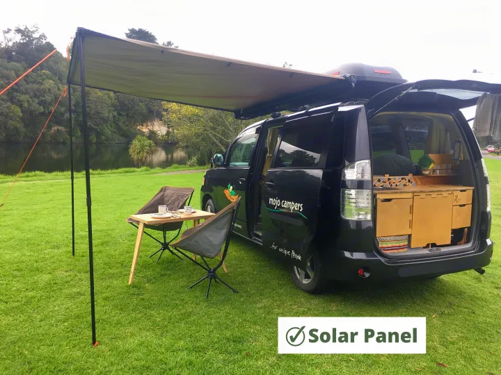 RV rental campervan with awning & outdoor setup by a scenic lake. Perfect for camping adventures.. Toyota Voxy 2004