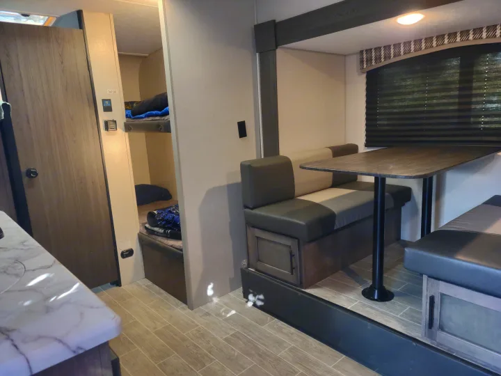 RV rental interior featuring a dinette with bench seating and built-in bunk beds for cozy travel accommodations.. Sonic Lite 2021