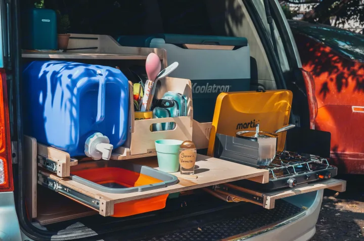 This RV rental features a compact pull-out kitchen: water tank, stove, sink, and cooler, perfect for van life adventures!. Chrysler Grand Caravan 2022
