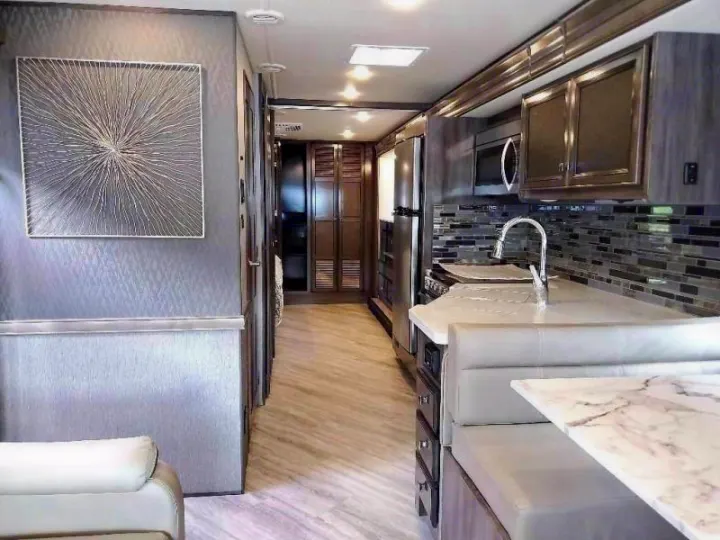Spacious, modern RV rental interior with fully equipped kitchen, dinette, and living area. Perfect for travel!. Fleetwood Fortis 2021
