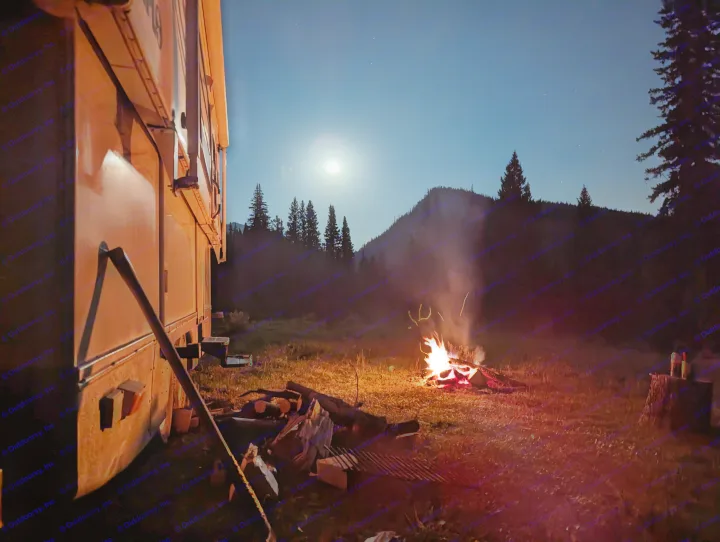 Night camping scene: a bright campfire illuminates an RV rental, with a full moon and starry sky over silhouetted mountains.. Hi Lo 2307c 2007