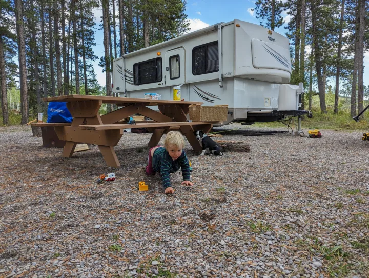 Family fun at the campsite! An RV rental is parked among pines, while a child plays and a dog rests by the picnic table.. Hi Lo 2307c 2007
