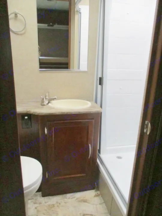 Explore this RV rental's compact bathroom, complete with a sink, mirror, toilet, and stand-up shower unit.. Forest River Coachmen Pursuit 2017