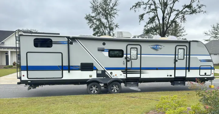 Experience travel freedom with this modern White Hawk RV rental. A light gray and blue travel trailer, ready for adventure.. Jayco White Hawk 2018