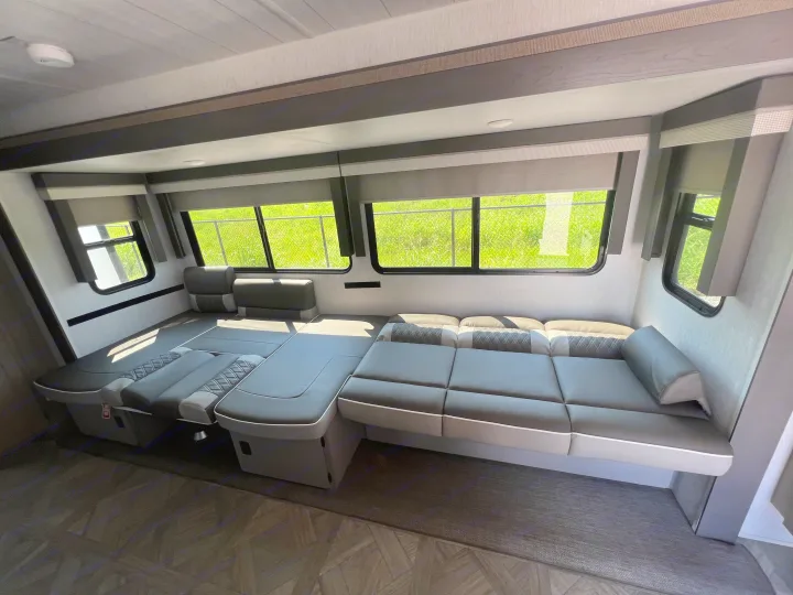Modern RV rental interior: large, convertible dinette/bed setup, perfect for mobile living.. Forest River 31KQBTS 2024