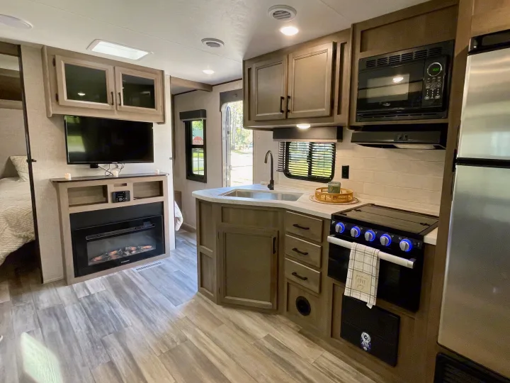 Spacious RV rental interior with modern kitchen, cozy fireplace, and comfortable living area.. Starcraft Autumn Ridge 2023