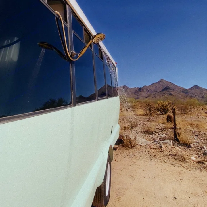 Gold outdoor shower on RV rental in desert, mountains in background.. Ford E450 1999