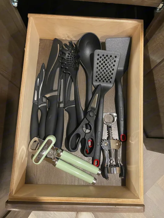 Organized RV rental kitchen drawer with black knives, spatulas, pasta server, shears, and bottle openers.. Forest River Salem 2022