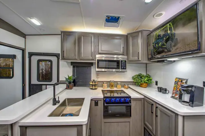 Spacious, well-equipped RV rental kitchen with sink, stove, microwave, and TV.. Cruiser Rv Corp Stryker 2022