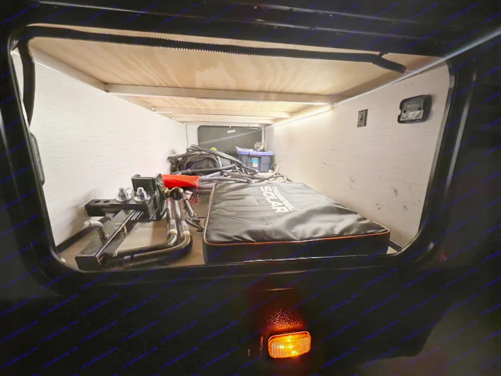 Inside an RV rental's brightly lit pass-through storage, showing solar gear & hitch equipment.. Cruiser RV MPG Ultra Lite 2022