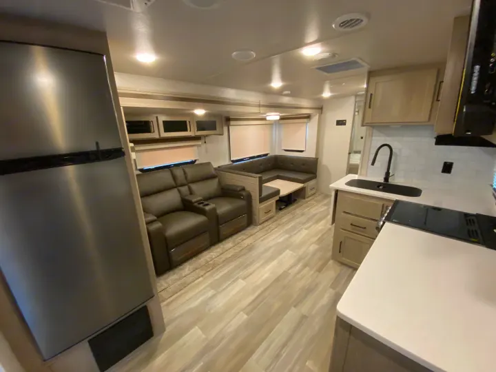Spacious rv rental interior featuring kitchen, recliners, dinette, and modern amenities for comfortable travel.. Forest River Rockwood 2023