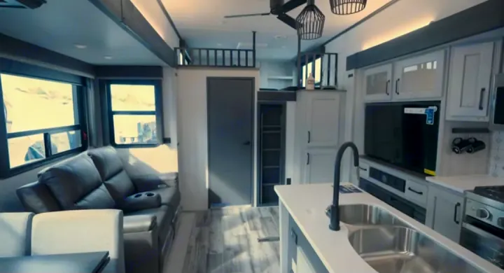 This RV rental interior showcases a modern kitchen, comfy living area, and unique overhead lofts, ready for your adventures.. Keystone RV Montana High Country 2023