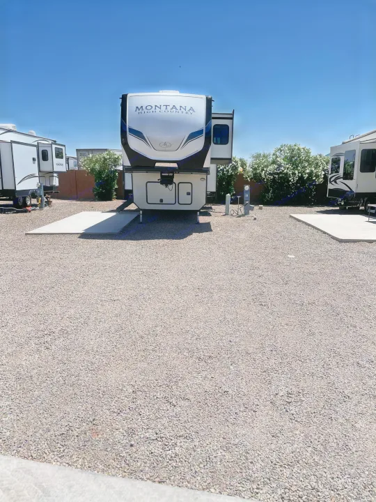 Montana High Country fifth-wheel RV at a gravel RV rental site with hookups.. Keystone RV Montana High Country 2023