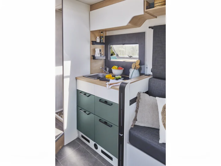 RV rental kitchen and seating area. Modern design with sink, green cabinets, and scenic window view.. PILOTE A696G Atlas 2025