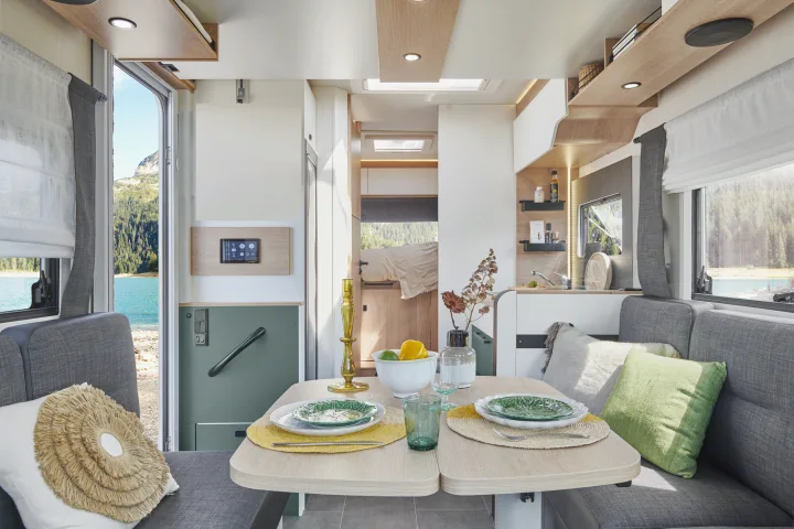 Spacious rv rental interior with dining, kitchen, and bedroom areas, boasting panoramic lake and mountain views.. PILOTE A696G Atlas 2025