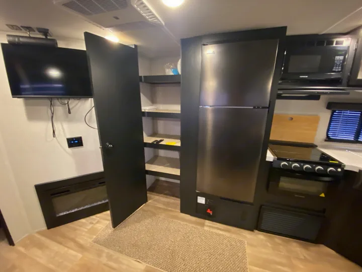 RV rental: Modern interior with full kitchen (fridge, microwave, stove), TV, electric fireplace, and pantry.. Forest River Cherokee 2021