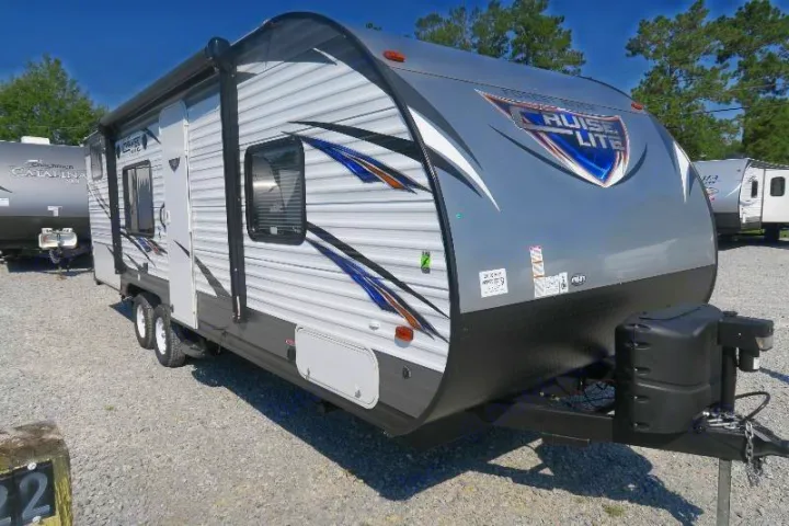 This gray and white Cruise Lite travel trailer, ideal for RV rental, features an extended awning, ready for adventure.. Forest River Cruise Lite 2017