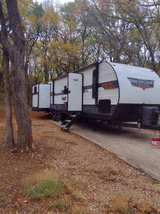This Forest River Wildwood **RV rental** is perfectly settled for a peaceful autumn stay at a wooded campsite.. Forest River Wildwood 2022