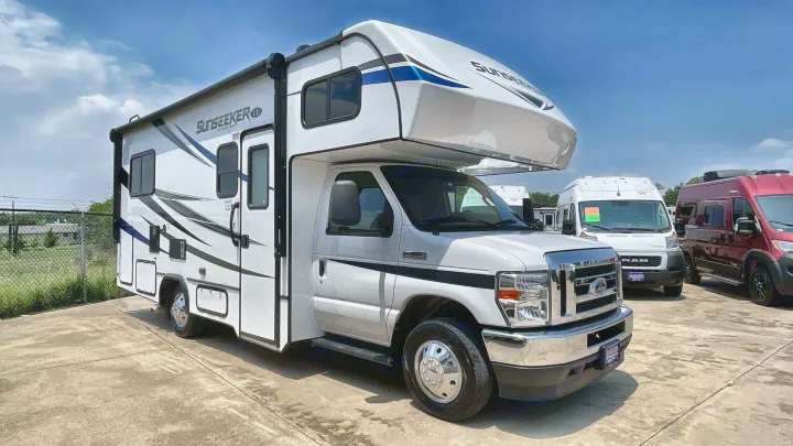 White Sunseeker Class C RV rental with blue graphics parked on concrete, ideal for your next travel adventure.. Forest River Sunseeker 2022