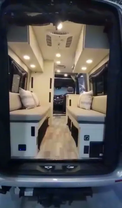 This bright RV rental interior offers a wide central aisle, two bench-beds, and overhead AC/lighting. Perfect for mobile home travel.. Cahaba Cahaba Class B 2022