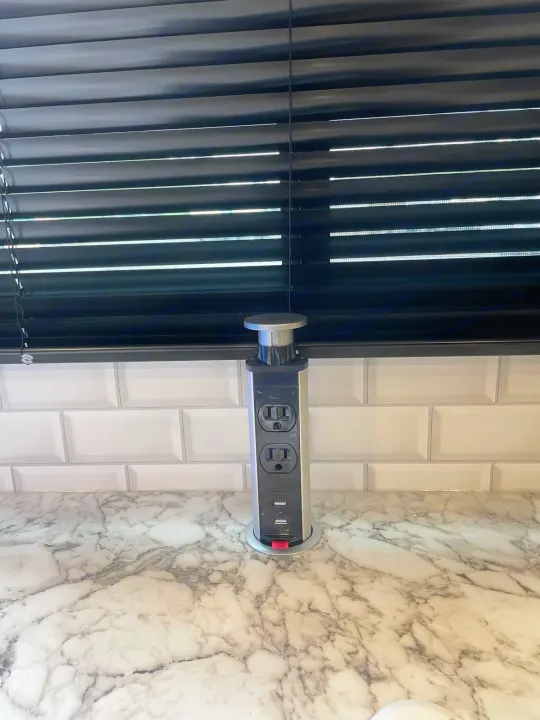 Modern pop-up electrical outlet on a marble counter offering AC and USB power, ideal for an RV rental.. Jayco Jay Feather 2022