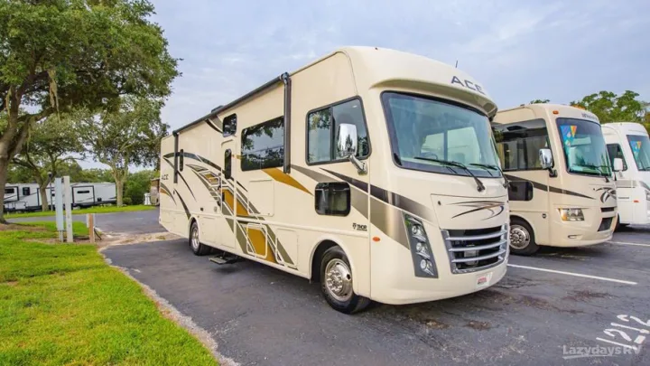 Large cream-colored Thor ACE Class A RVs parked at an outdoor RV rental lot. Explore these spacious motorhomes today!. Thor A.C.E. 2020