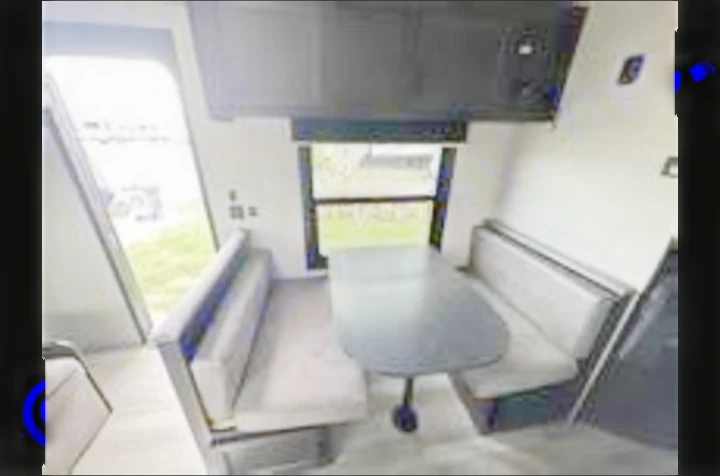This RV rental interior showcases a cozy dinette with two opposing benches and a table, plus overhead cabinets for compact living.. Jayco Jay Flight 2023