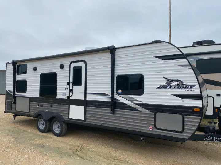 Detailed side view of a white & gray Jayco Jay Flight travel trailer, ideal for an RV rental or camping adventure.. Jayco Jay Flight 2023