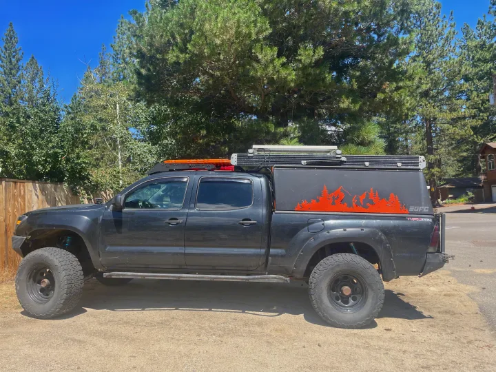 This black overlanding Toyota Tacoma pickup truck with a pop-top camper, ideal for RV rental adventures, is ready for off-road camping.. Toyota Tacoma - GoFastCamper 2007