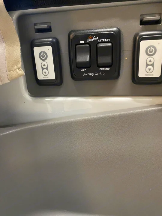 RV rental interior: A control panel featuring switches for awning on/off/extend/retract and other chassis controls.. Airstream Interstate 2017