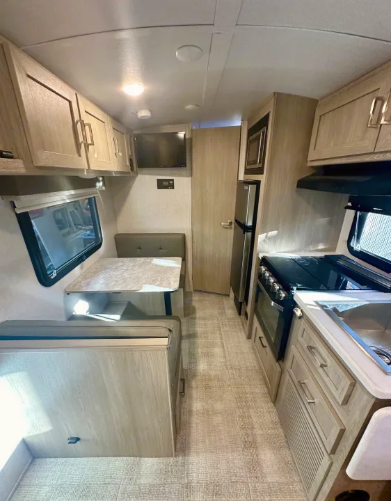 Step inside this modern RV rental, featuring a cozy dinette, fully-equipped kitchen, and ample storage for your road trip.. Forest River Geo Pro 2021