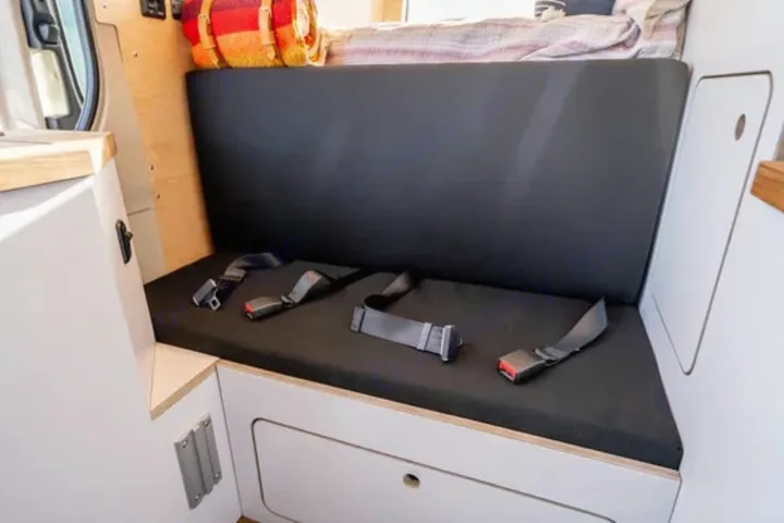 RV rental interior: a practical black bench seat with three seatbelts ensures safe and comfortable passenger travel.. VanCraft VanCraft Class B 2022