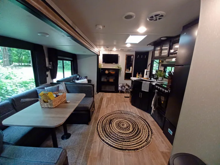 This RV rental's modern interior offers a bright living/dining area, a full kitchen, and ample amenities for comfortable travel.. Forest River Cherokee 2021
