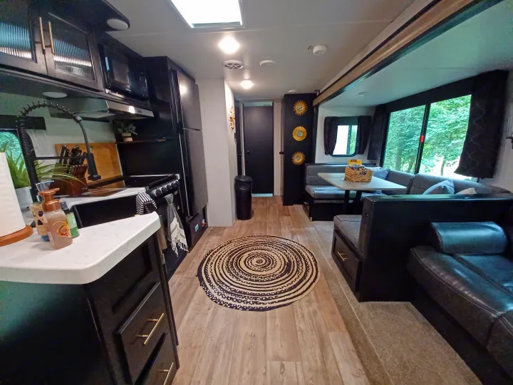Spacious, modern RV rental interior featuring kitchen, dining, and living areas.. Forest River Cherokee 2021