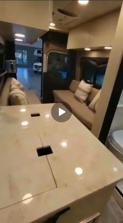 Explore this spacious, modern RV rental interior. Features comfortable sofas, a sleek countertop, and bright lighting for your travels.. Cahaba Cahaba Class B 2022
