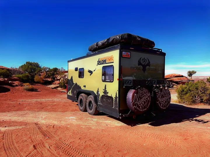 Rugged off-road Xplore RV rental on red desert terrain under a clear sky. Your next adventure awaits!. Imperial Outdoors XploreRV 2023