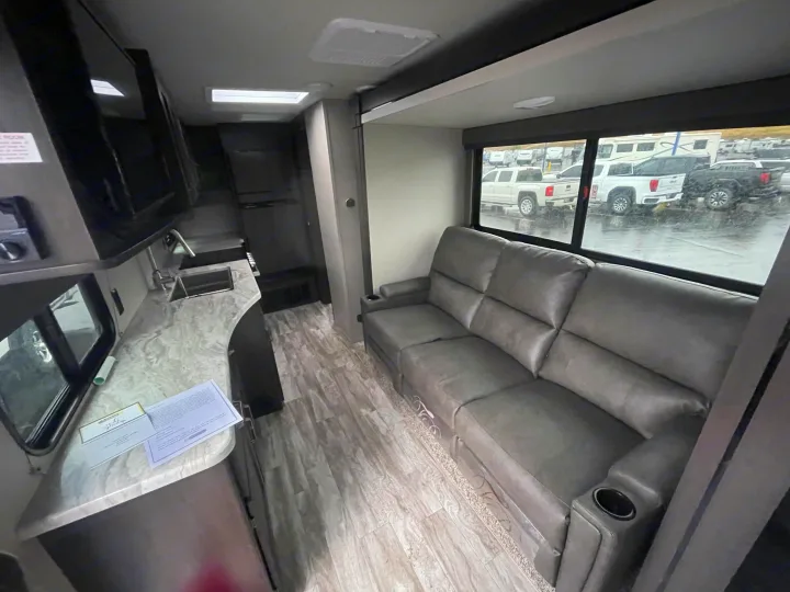 Explore this modern RV rental interior! Features a cozy gray sofa, full kitchen with sink, and spacious living area. Ready for your adventure.. Grand Design Transcend Xplor 2022