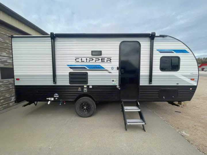A grey and black Coachmen Clipper travel trailer, perfect for rv rental, parked on concrete with its entry steps deployed.. Coachmen Clipper 2024