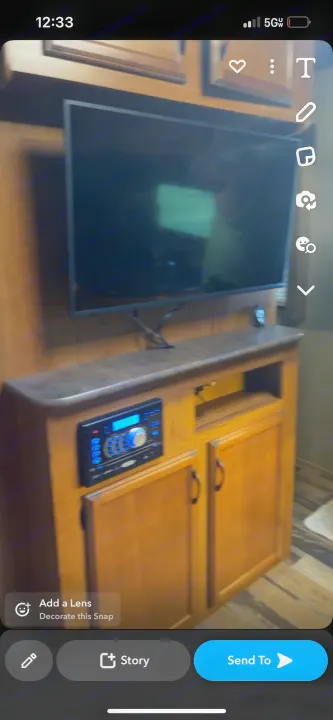 RV rental's entertainment system: wall-mounted TV above a console with a stereo. Cozy living space.. Starcraft Travel Star 2016