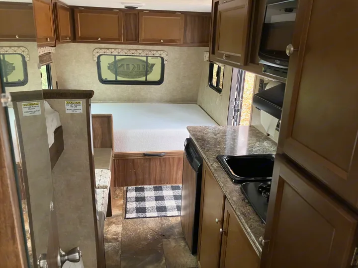 Spacious RV rental interior featuring kitchen, bed, and dining nook. Enjoy comfort on the road!. Forest River Viking 2016