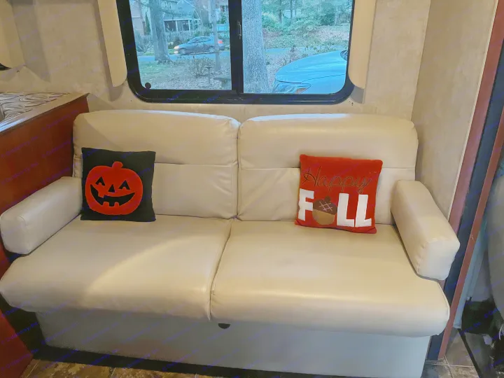 Relax in this RV rental! Cozy interior with a cream sofa, complete with festive pumpkin & "Happy Fall" pillows and a scenic view.. Winnebago Winnebago 2014
