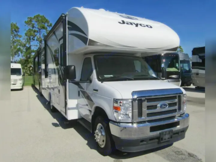 A white Jayco Class C motorhome, an ideal rv rental, with black accents, parked outside on a sunny day.. Jayco Redhawk 2022
