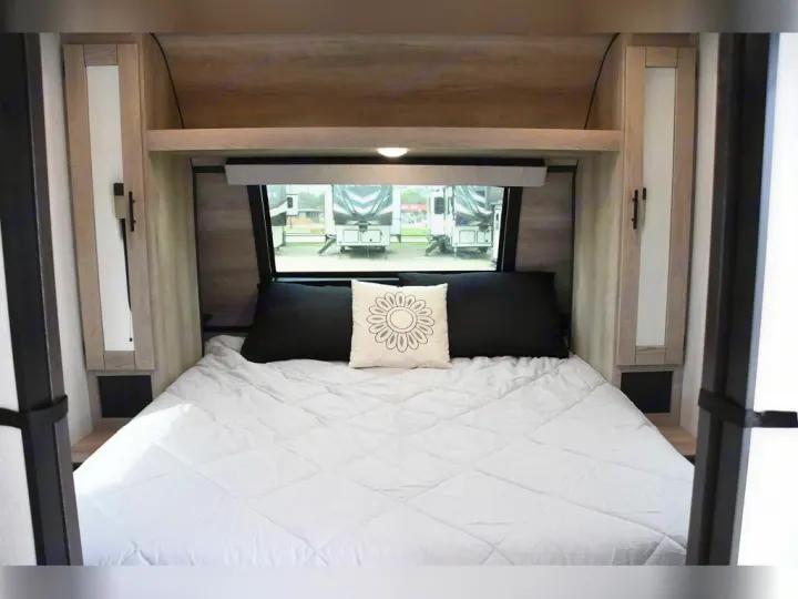 Cozy RV rental bedroom features a comfy bed with storage cabinets, a window, and modern decor for travel comfort.. KZ Connect C291BHK 2023