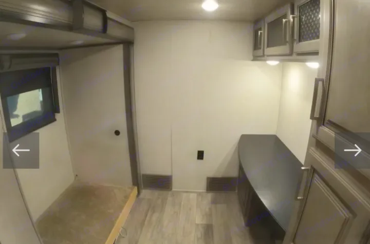 RV rental interior showcasing a bunk bed, window, and wall vents. Modern cabinets and a curved counter complete the space.. Keystone RV Montana 2021