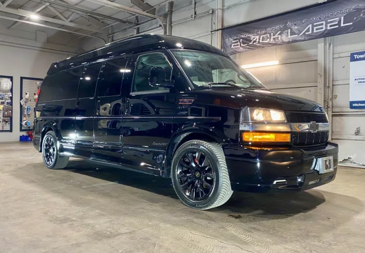 A sleek black Limited SS conversion van, with glossy paint and dark custom wheels, ideal for luxury RV rental trips.. Passenger Van 9 Passenger Van 2024