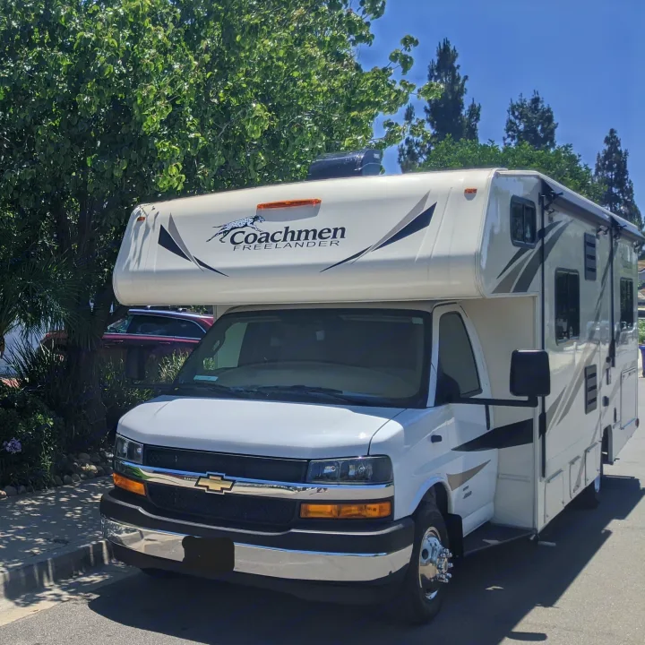 A white Coachmen Freelander Class C RV, ideal for an RV rental, is parked on a sunny day, ready for adventure.. Forest River Coachmen Freelander 2020