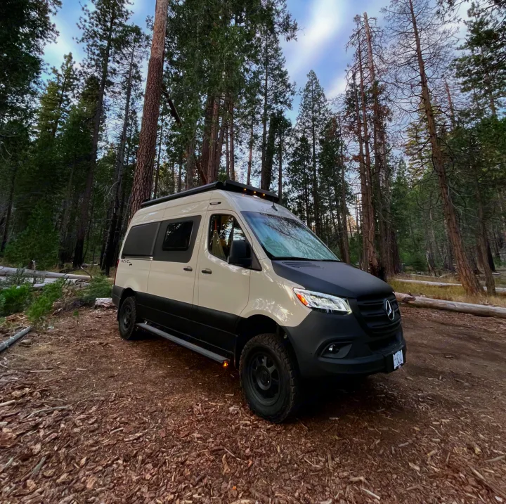 Experience nature with this rugged Winnebago Revel Sprinter van rv rental, parked in a scenic forest.. Winnebago Revel 2023
