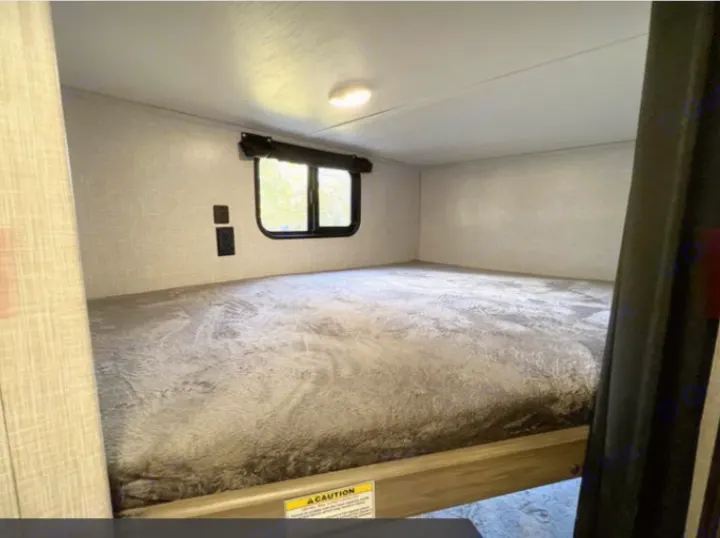 Cozy RV rental bunk bed interior with a window, wall outlets, and a comfortable mattress for your next adventure.. Crossroads RV Zinger Lite 2022